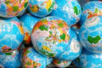 Viele kleine als Globus bedruckte Kugeln liegen auf einem Haufen.