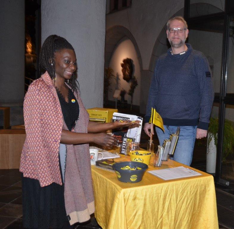 Dianka Kouamé schaut nach der Lesung aus "Kleiner Bruder" in der Aachener Citykirche am Amnesty Infostand vorbei.
