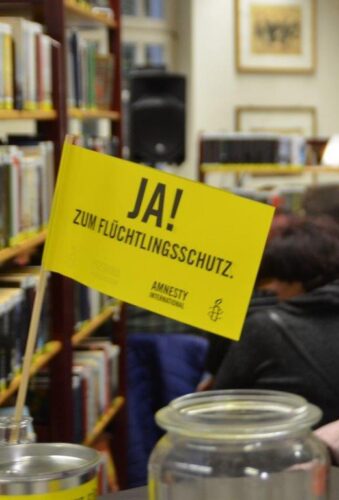 Kleine Amnesty-Fahne mit der Aufschrift "JA! zum Flüchtlingsschutz." in der Stadtbücherrei Stolberg