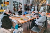 Strickende und Kaffee trinkende Menschen in an einem großen Tisch in der Aachener Citykirche