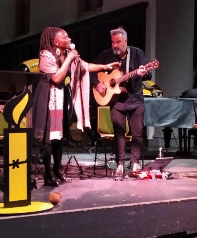 Dianka Kouamé singt und Sazan Azodi spielt Gitarre bei der Lesung aus "Kleiner Bruder" in der Aachener Citykirche.