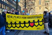 Menschen halten bei einer Demo auf dem Aachener Katschhof ein Amnesty-Banner mit Aufschrift "Kein Platz für Rassismus!"