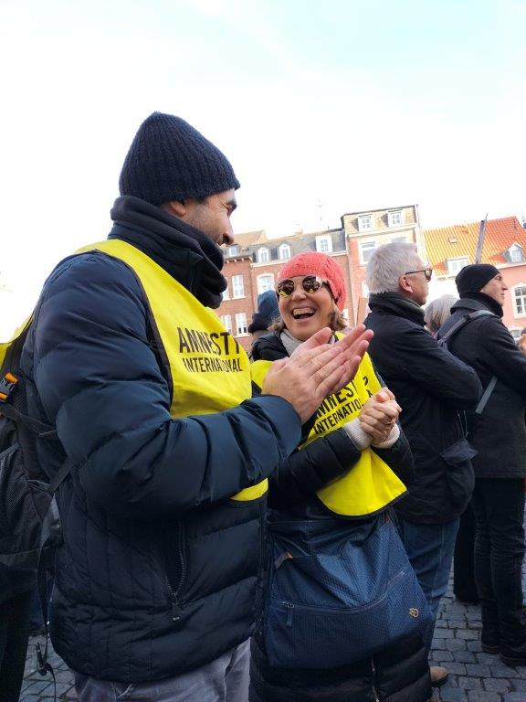 Menschen mit gelben Amnesty-Leibchen bei einer Demo auf dem Aachener Katschhof