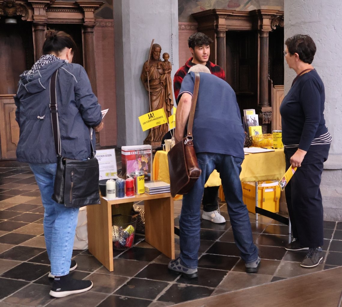 Menschen informieren sich am Amnesty Infostand in der Citykirche.