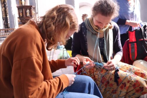 Zwei engagierte Strickerinnen entwirren Wolle mit allen verfügbaren Händen und Zähnen :-)