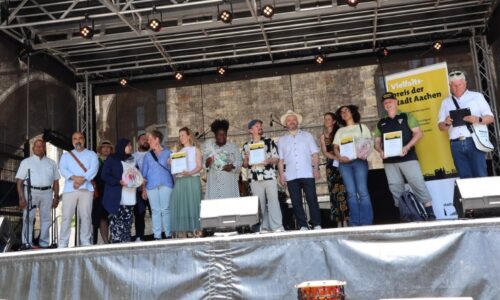 Viele unterschiedliche Personen auf der Bühne vor dem Aachener Rathaus, die mit dem Vielfaltspreis der Stadt Aachen ausgezeichnet wurden.