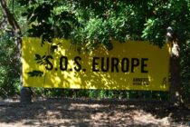 Amnesty International Banner aufgespannt im Schatten unter Bäumen mit der Aufschrift "S.O.S. Europe"